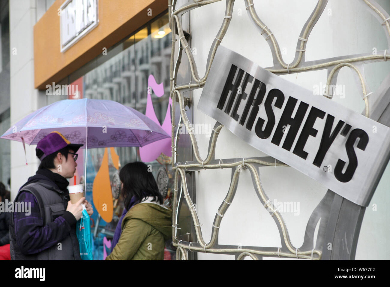 ---- Fußgänger vorbei an einem Geschäft von Hershey's Kisses Schokolade in Shanghai, China, 7. Februar 2010. Us-Schokolade Riese der Hershey Co. hat qu Stockfoto