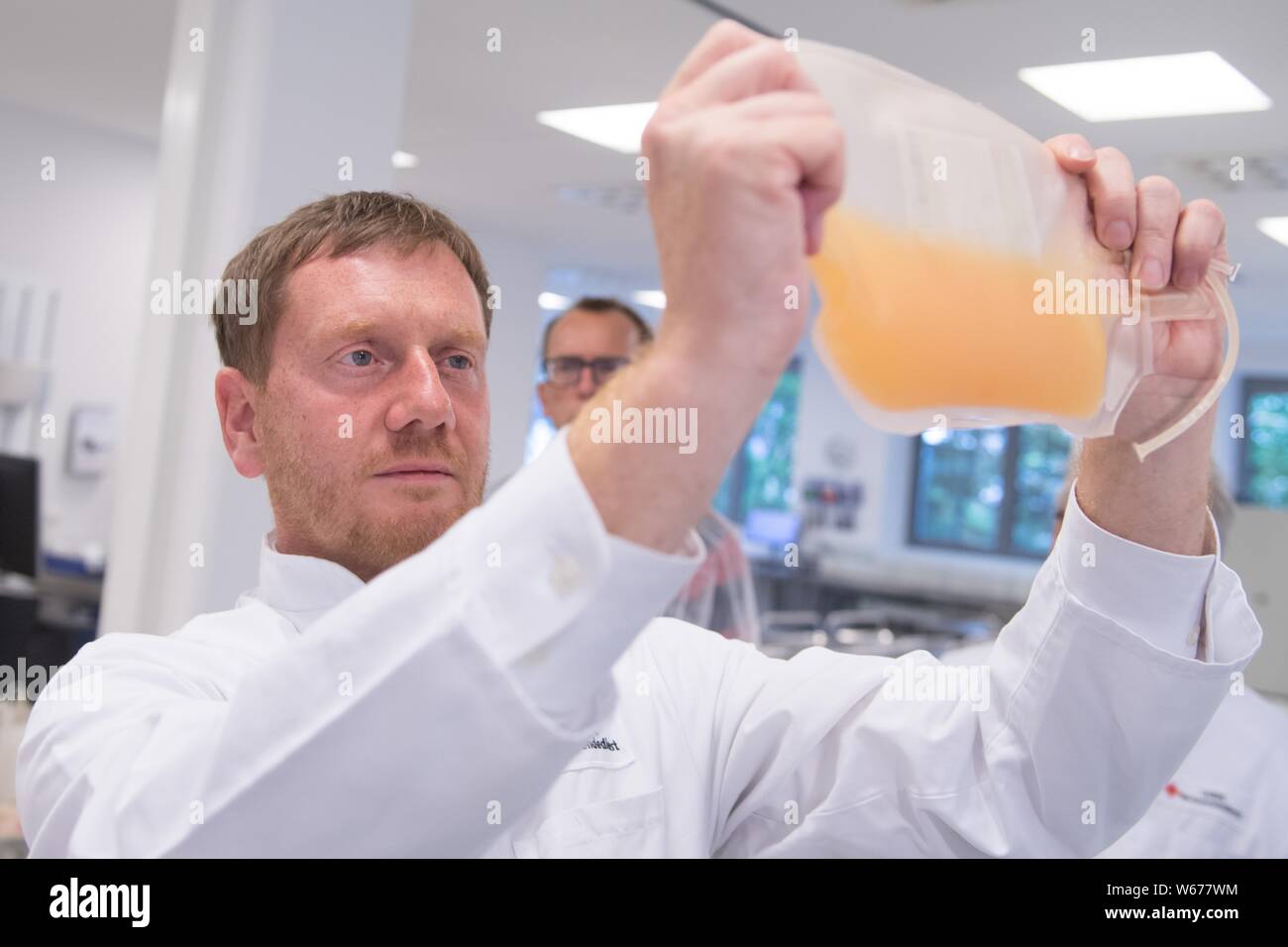 Dresden, Deutschland. Juli 31, 2019. Michael Kretschmer (CDU), Ministerpräsident von Sachsen, hält ein Beutel von Blutplasma in das Blut Vorbereitung Einheit des DRK Blutspendedienst Nord. Bei seinem Besuch, der Ministerpräsident informierte sich über die aktuelle blutversorgung Situation in Sachsen. Credit: Sebastian Kahnert/dpa-Zentralbild/dpa/Alamy leben Nachrichten Stockfoto