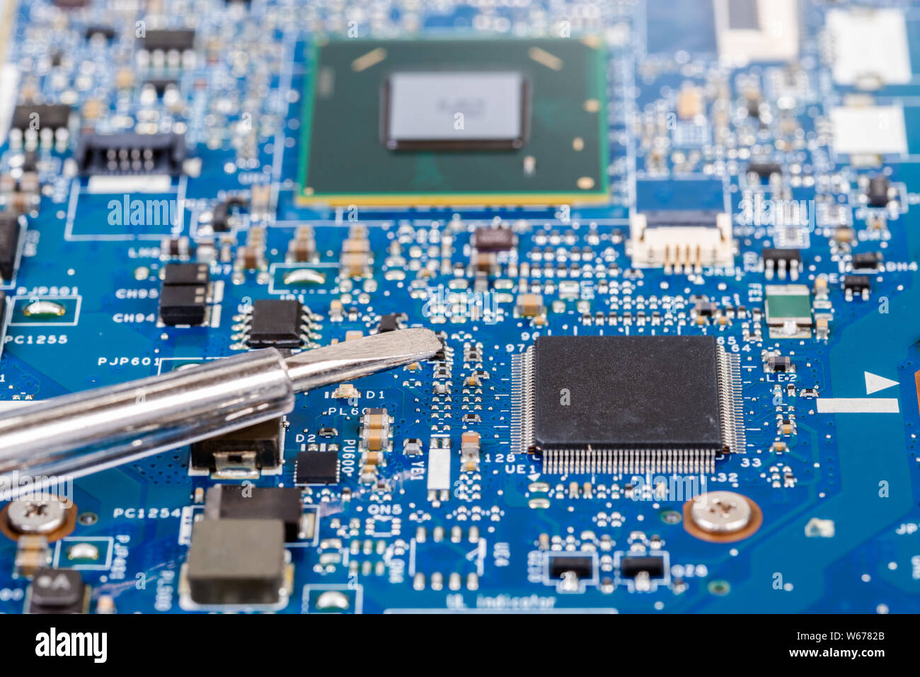 Nahaufnahme von einem Schraubendreher auf einem Laptop Platine mit Prozessor. Selektive konzentrieren. Stockfoto
