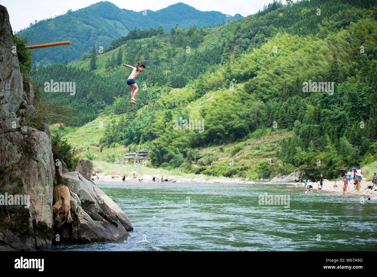 Ein Mann der Zhuang, die ethnischen Minderheiten angehören, springt ins Wasser Das Wasser springen Tiaoshui Festival (Festival) in Congjiang County, qiandongnan Miao zu feiern. Stockfoto