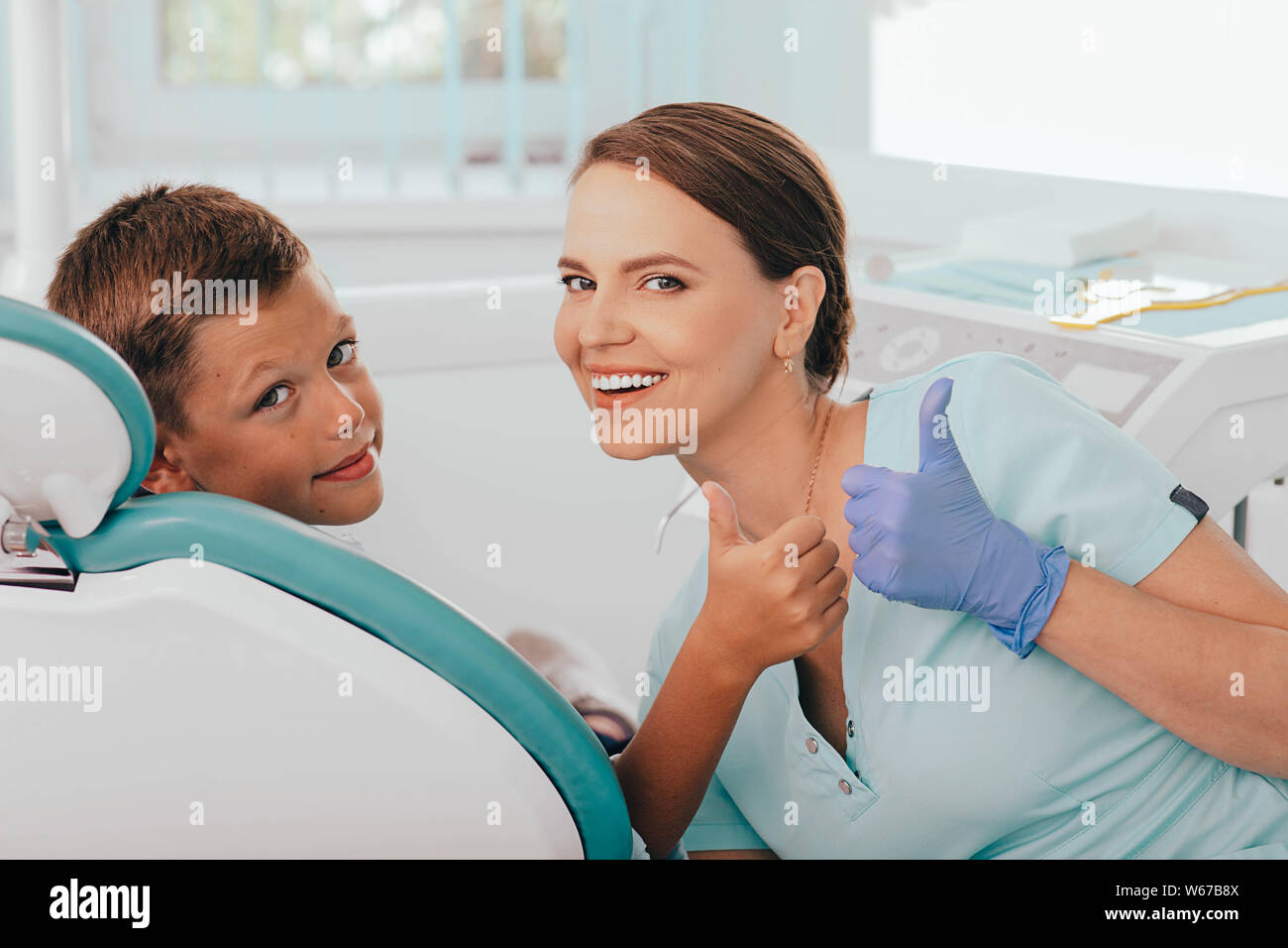 Cute Boy und positive weibliche Zahnarzt mit Daumen nach oben. Kind zahnmedizinische Behandlung Stockfoto