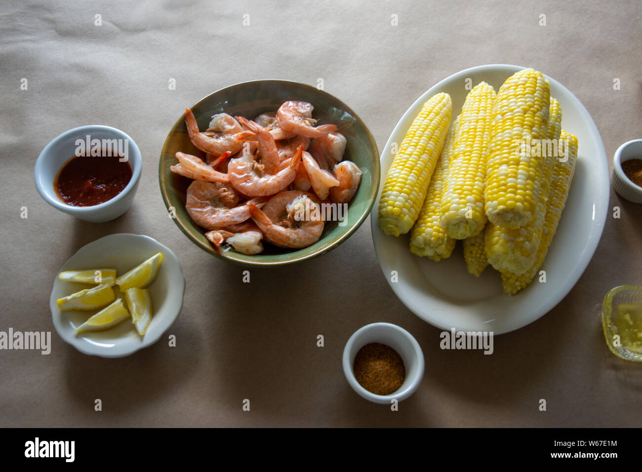 Gedämpfte Garnelen und heiße frischer Mais auf dem Cobb, mit Beilagen. Stockfoto
