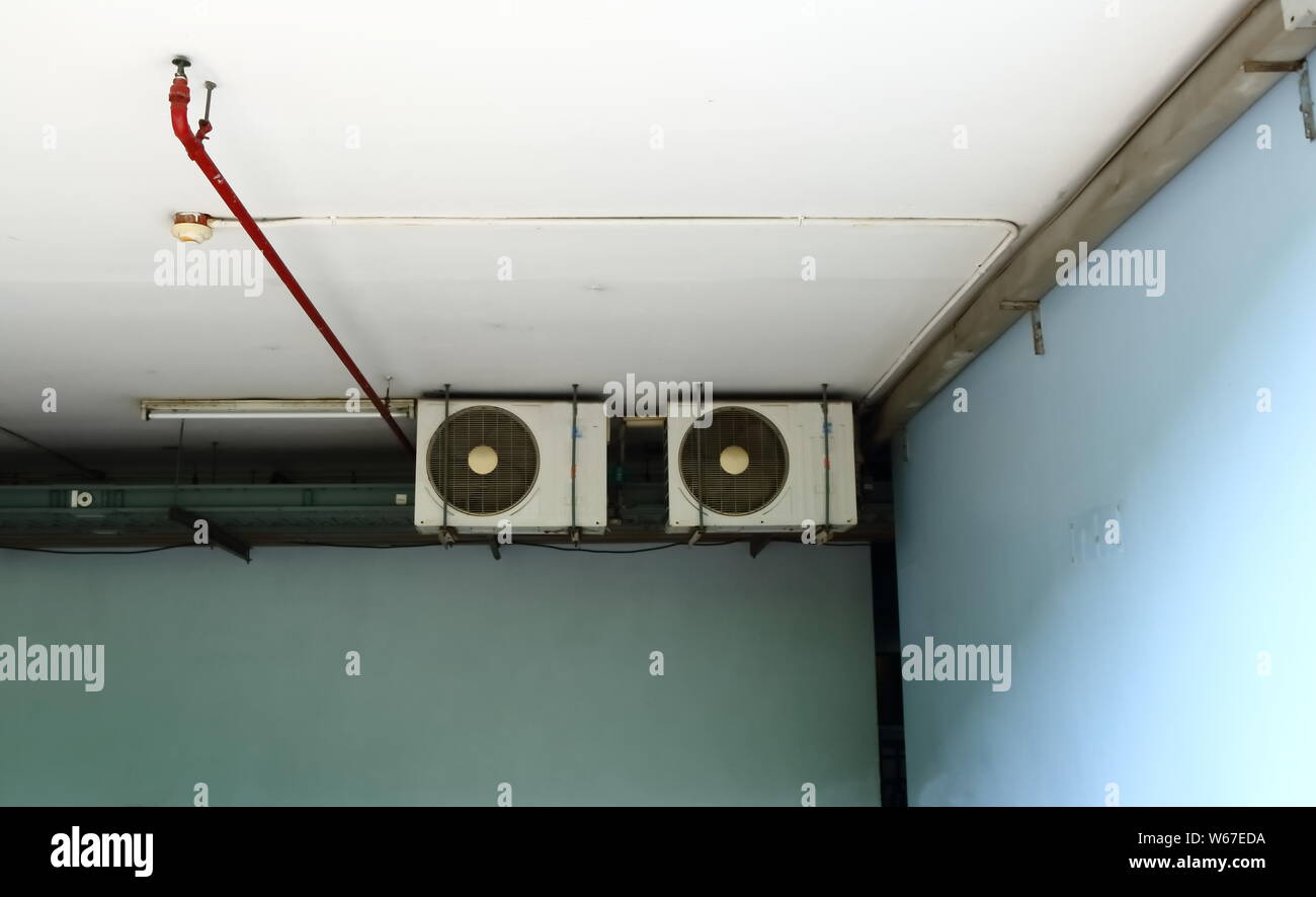 Gruppe der verflüssigungssätze von Klimaanlagen, Sprinkleranlagen und Wärmemelder an der Decke eines Gebäudes installiert Stockfoto