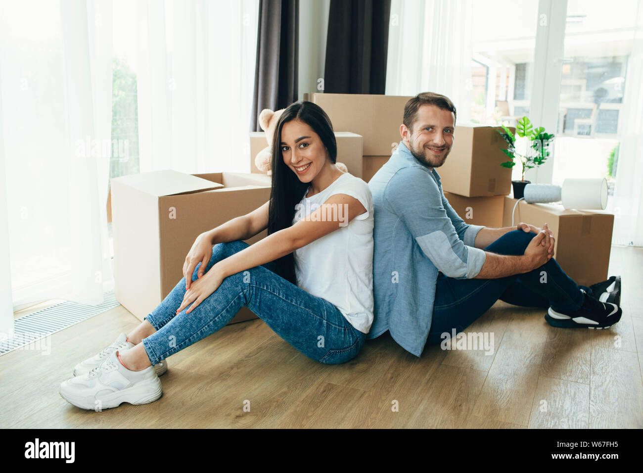 Verschieben neues Haus. Junge glückliches Paar Auspacken der Kartons in Ihre neue Wohnung Stockfoto