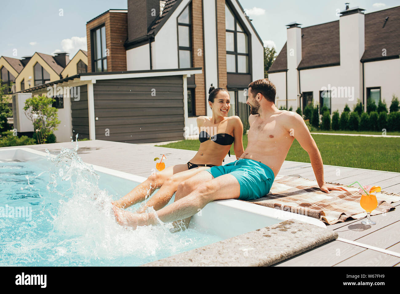 Mann und eine Frau schauen liebevoll einander an, während in den Pool. Auf Wiedersehen, hi Sommer Urlaub - Schwimmen und Bräunen Stockfoto