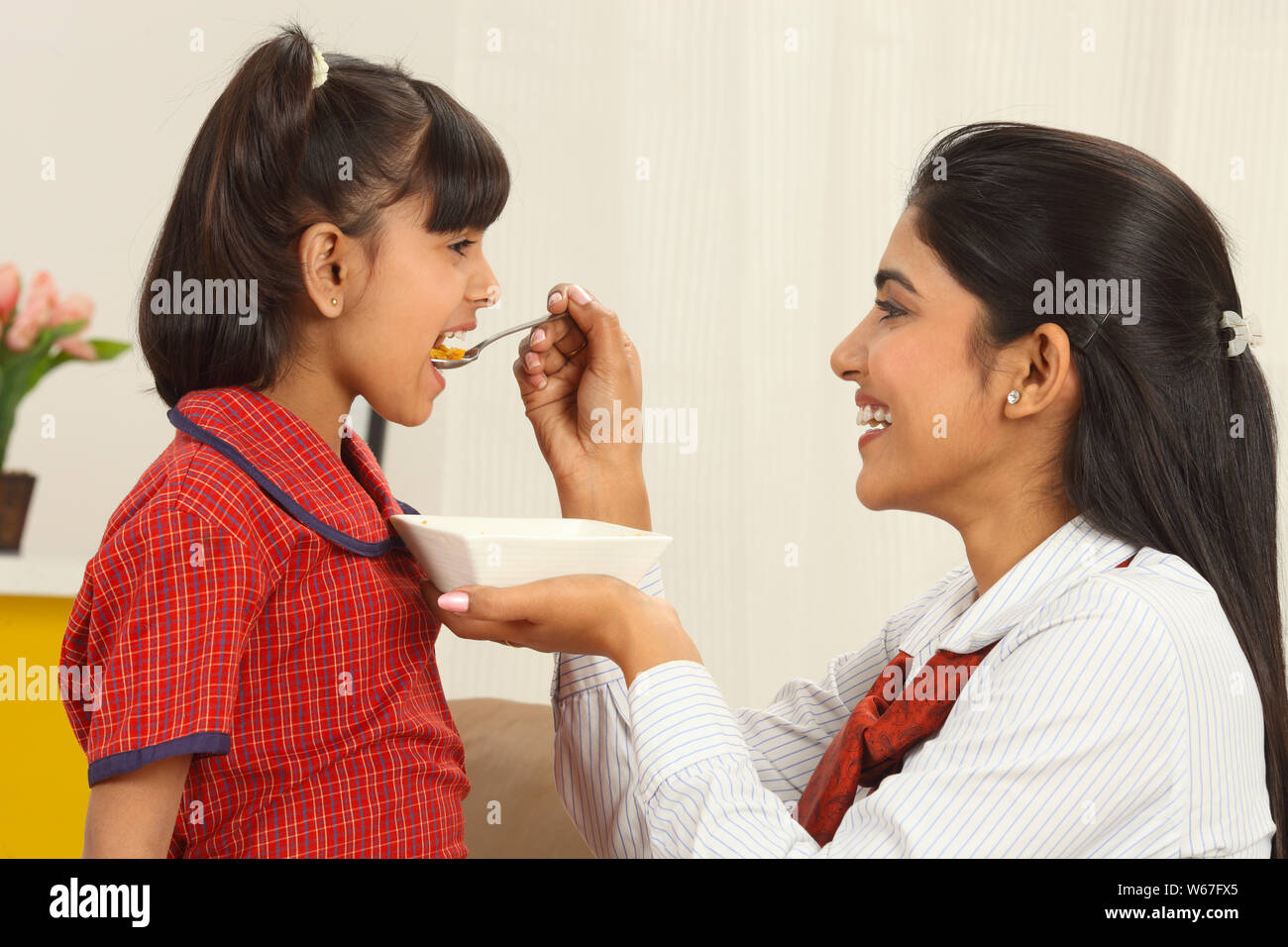 Geschäftsfrau Fütterung ihrer Tochter Stockfoto