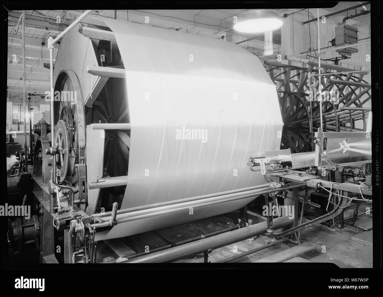 Paterson, New Jersey - Textilien. Jackson Wicklung und Verziehen. Bild von einem Sipp-Eastwood DY Art der High Speed Warper. Diese Maschine ist ähnlich wie oben, außer dass die Verwerfung auf die alte Art von creel gewickelt ist. Nach dem Warp ist es strahlte. Auf diese Art von Maschine dauert es 2-1/4 bis 2-1/2 Stunden das übliche Art der Verwerfung zu machen. Diese Schätzung der Zeit können variieren leicht die eine oder andere Weise, je nach der Anzahl der Abschnitte, Länge der Verwerfung, etc. Stockfoto