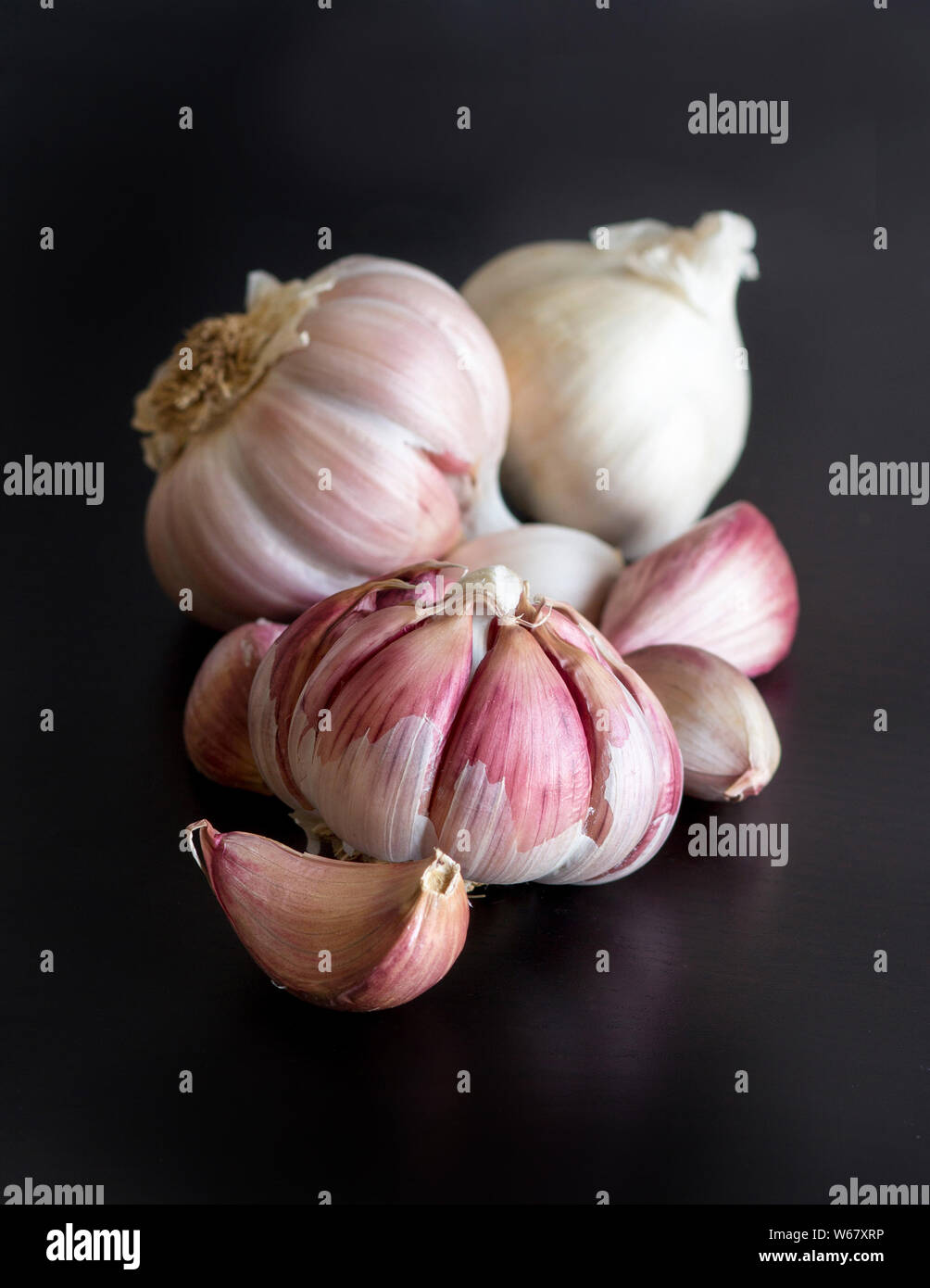 Ganze und Split frischer Knoblauch auf einem Schwarzen Tisch Stockfoto