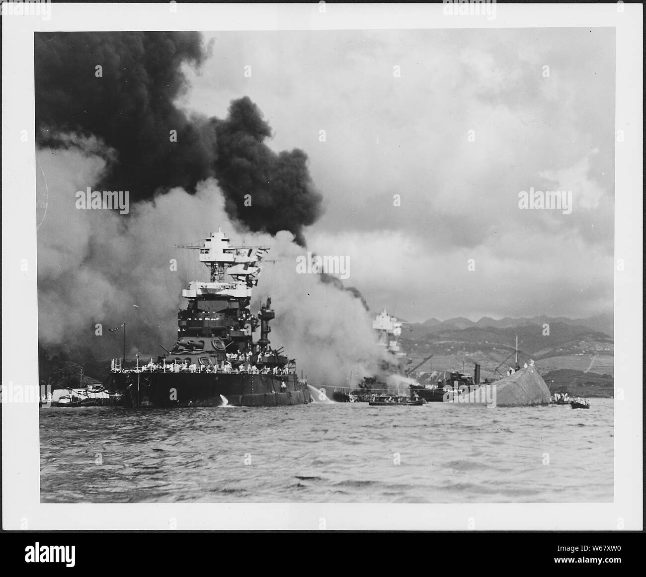 Foto des Gekenterten USS Oklahoma und ein leicht beschädigte USS Maryland Stockfoto