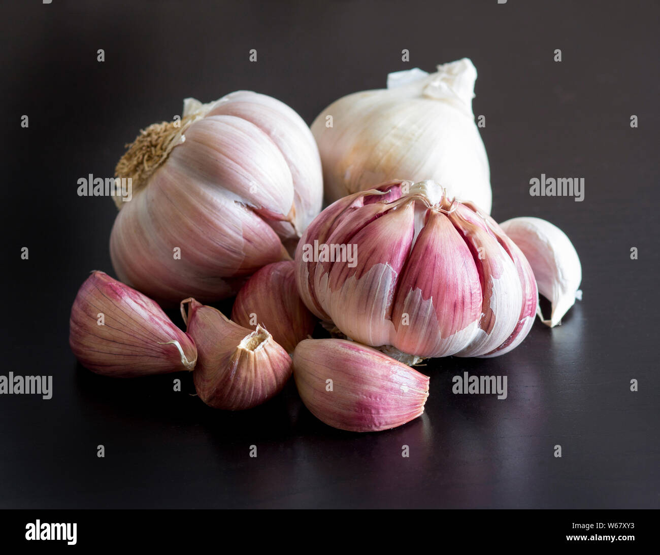 Ganze und Split frischer Knoblauch auf einem Schwarzen Tisch Stockfoto
