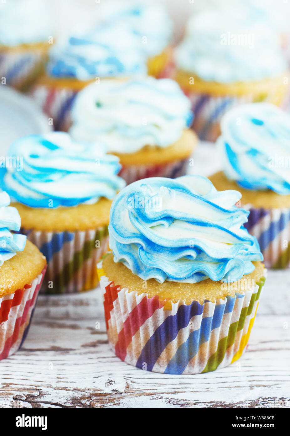 Kinder kleine Kuchen mit Sahne cap blau auf weiß Holz- Hintergrund Stockfoto