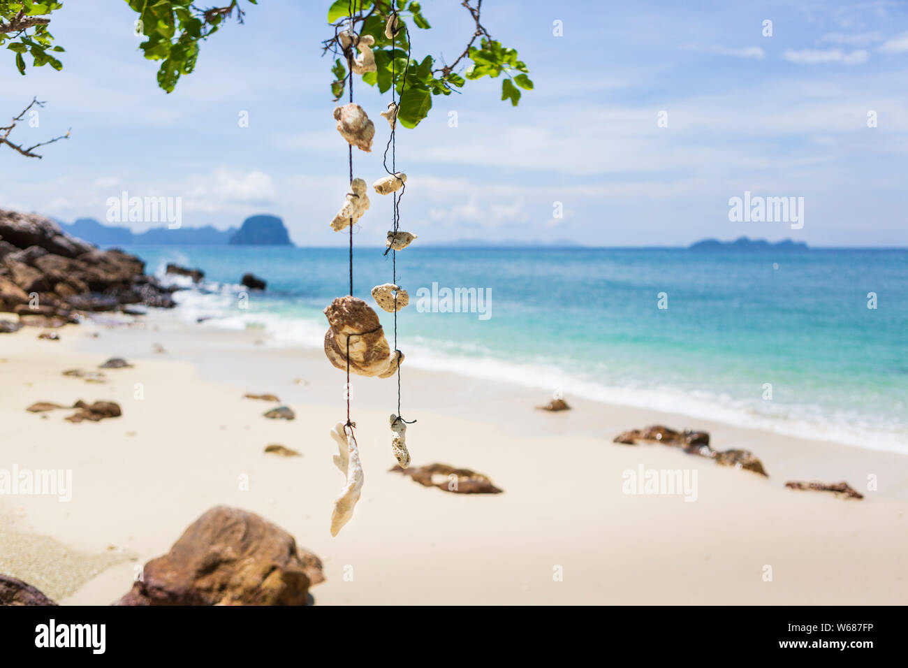 Leerer Traum Strand mit weißem Sand auf der Insel Koh Ngai, Thailand. Muscheln hängen von einem Ast auf eine Zeichenkette. Stockfoto