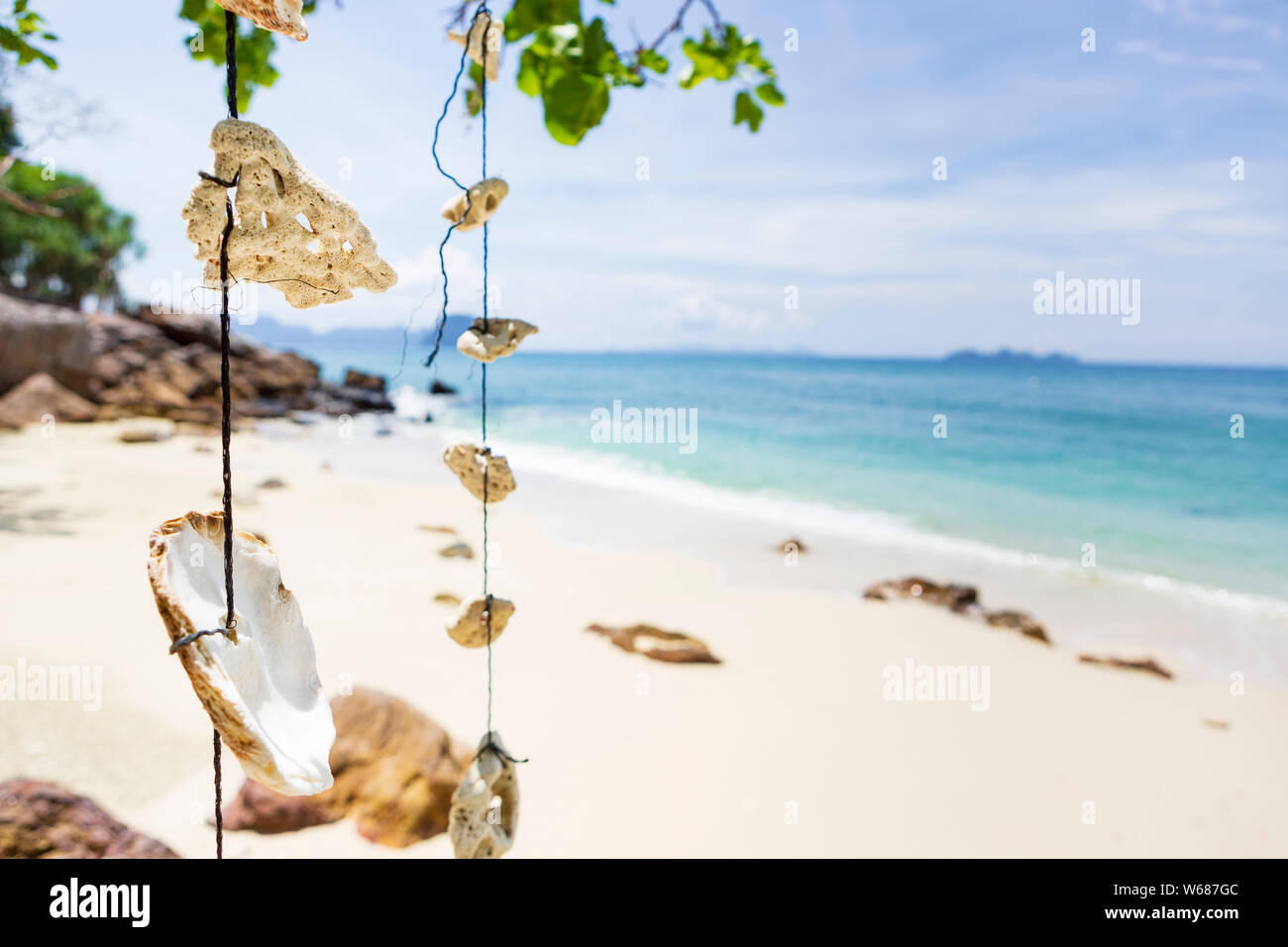 Leerer Traum Strand mit weißem Sand auf der Insel Koh Ngai, Thailand. Muscheln hängen von einem Ast auf eine Zeichenkette. Stockfoto