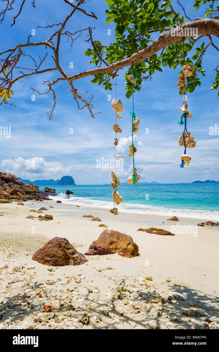 Leerer Traum Strand mit weißem Sand auf der Insel Koh Ngai, Thailand. Muscheln hängen von einem Ast auf eine Zeichenkette. Stockfoto