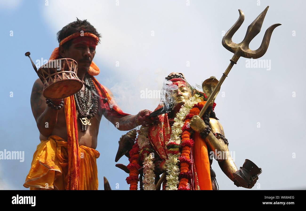 Kathmandu, Nepal. Juli 31, 2019. Ein hinduistischer Priester gießt Milch, als er Gebete Angebote von Lord Shiva an Shiva Tempel zu Idol während des heiligen Monats Shrawan. Credit: Archana Shrestha/Pacific Press/Alamy leben Nachrichten Stockfoto