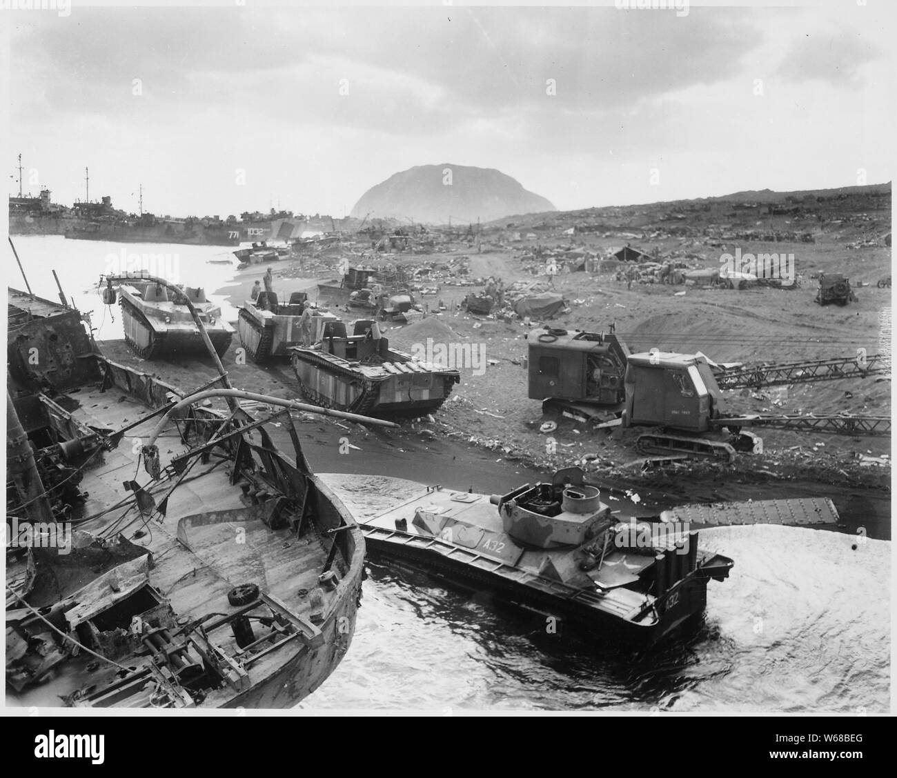 Zerschlagen von japanischen Mörtel und shellfire, durch Iwo der verräterische schwarze Asche Sands, amtracs und anderen Fahrzeugen des Krieges gefangen legen Sie auf dem schwarzen Sand von der vulkanischen Festung klopfte.; Allgemeine Hinweise: Verwenden Sie Krieg und Konflikt Nummer 1220 bei der Bestellung eine Reproduktion oder Anforderung von Informationen zu diesem Bild. Stockfoto