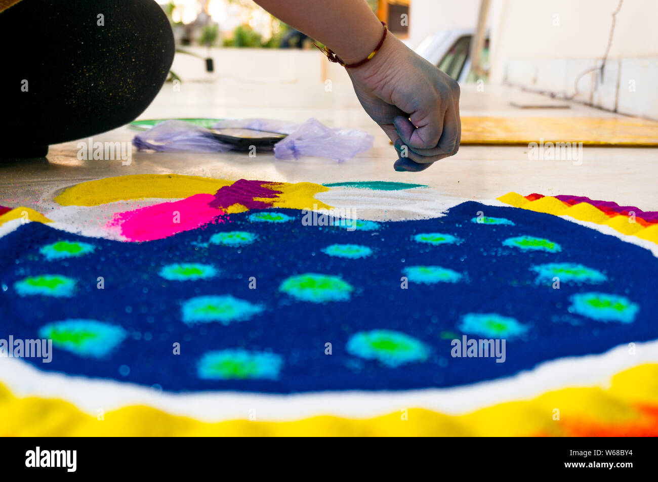 Hand des jungen indischen Mädchen machen rangoli aus farbigem Puder auf diwali Eva. Diese schöne Designs sind in jedem Hindu zu verzieren und celeb gemacht Stockfoto