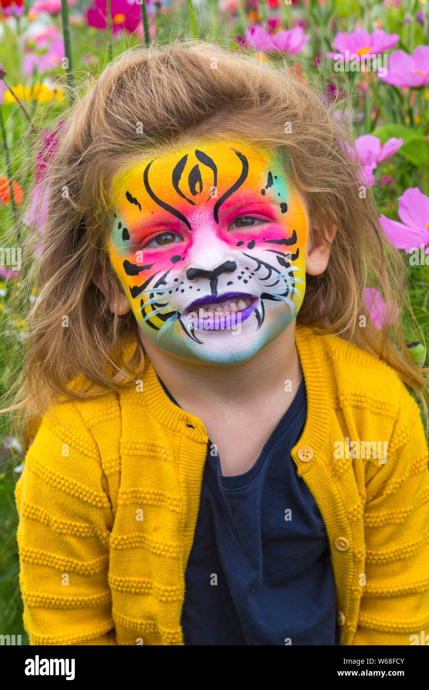 New Milton, Hampshire, UK. 31. Juli 2019. Tausende strömen in den zweiten Tag des New Forest & Hampshire County. Lola 2.5 mit gemalten lion Gesicht mit Farben der Blumen um Matching in Blumenwiese mit Cosmos Blumen im Alter. Credit: Carolyn Jenkins/Alamy leben Nachrichten Stockfoto