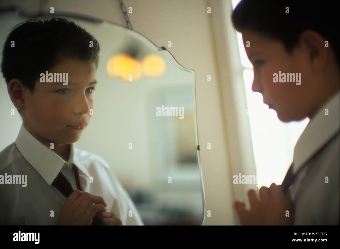 Ein kleiner Junge ist, sich vor dem Spiegel. Stockfoto