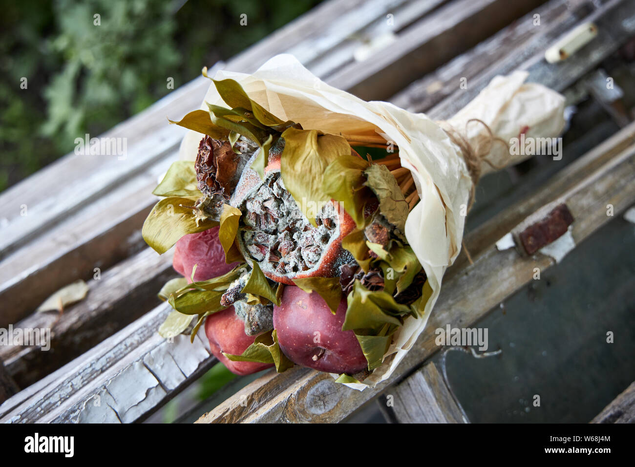 Haufen verfaulten Früchte und verwelkte Blumen lag auf alte hölzerne Bretter Stockfoto