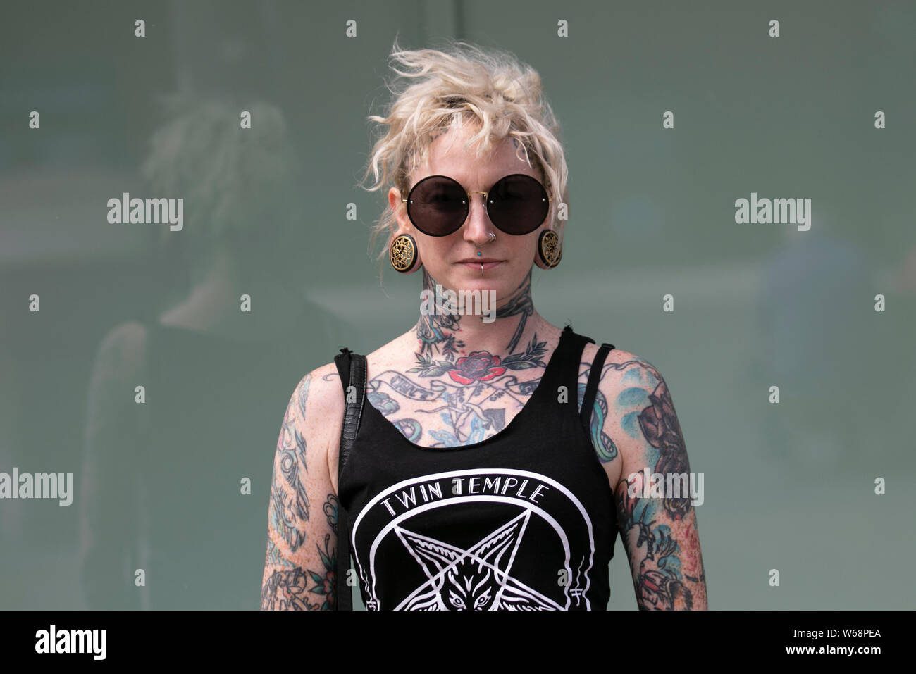 Weibliche Körper-Tattoos; Bobbie mit zerzaustem welligen blonden lob-Haarschnitt aus Texas, Mitglied der Rock Band beim Rebellion Festival, dem größten Punk-Festival der Welt in Blackpool. Anfang August finden in den Winter Gardens von Blackpool zahlreiche Punk-Bands statt, die 21. zum Rebellion Festival eingeladen wurden, das Tausende von Touristen in das Resort zieht. An über 4 Tagen im August treffen sich in Blackpool die besten taoed Punk zu diesem gesellschaftlichen Event des Jahres mit 4 Tagen Musik auf 6 Bühnen mit Massen von Bands. Stockfoto