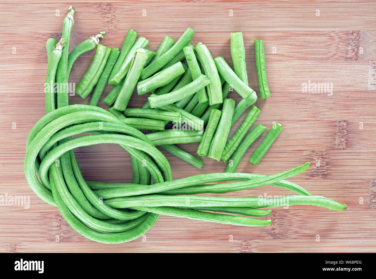 Grüne frische lange Bohnen auf Schneidebrett Stockfoto