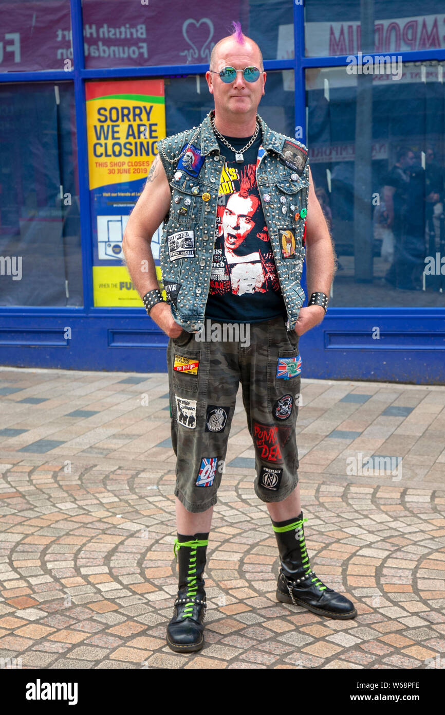 T-Shirts, Used Jeans und Doc martin Stiefel. Männliche Punk-Mode in Blackpool, Lancashire, Großbritannien. Juli 2019. Rebellion Festival das größte Punk-Festival der Welt in Blackpool. Anfang August finden in den Wintergärten von Blackpool zahlreiche Punk-Bands für das Rebellion Festival 21. statt, das Tausende von Touristen anzieht. Jeden August kommen in Blackpool über 4 Tage lang die Besten von Punk zu diesem gesellschaftlichen Ereignis des Jahres zusammen, mit 4 Tagen Musik auf 6 Bühnen mit Massen von Bands. Stockfoto