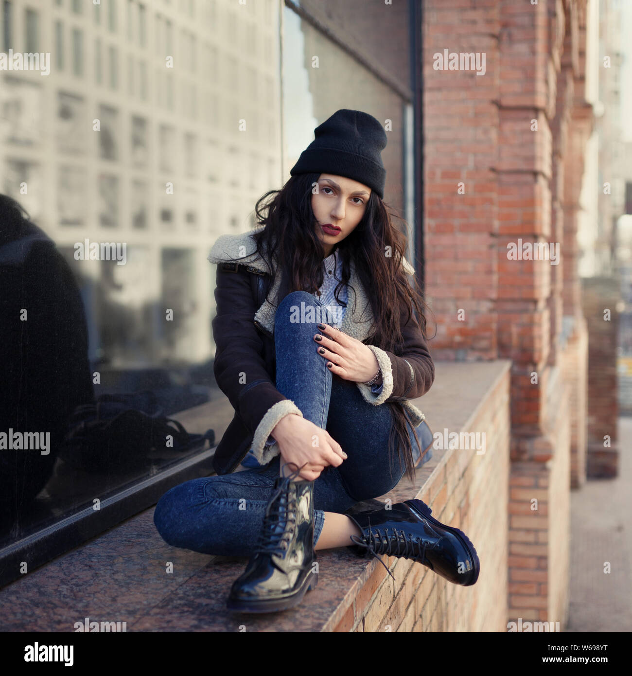 Outdoor Lifestyle Portrait von hübschen jungen Mädchen, tragen hipster Swag grunge Style auf der städtischen Hintergrund. Tragen Hut und Jeans mit Rucksack. Feder fa Stockfoto