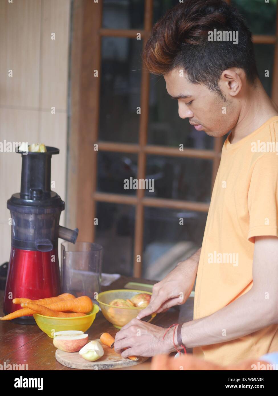 14. April 2019 - Kediri, Indonesien : ein junger indonesischer Mann, der Saft mit einem langsamen Entsafter zubereitete. Stockfoto