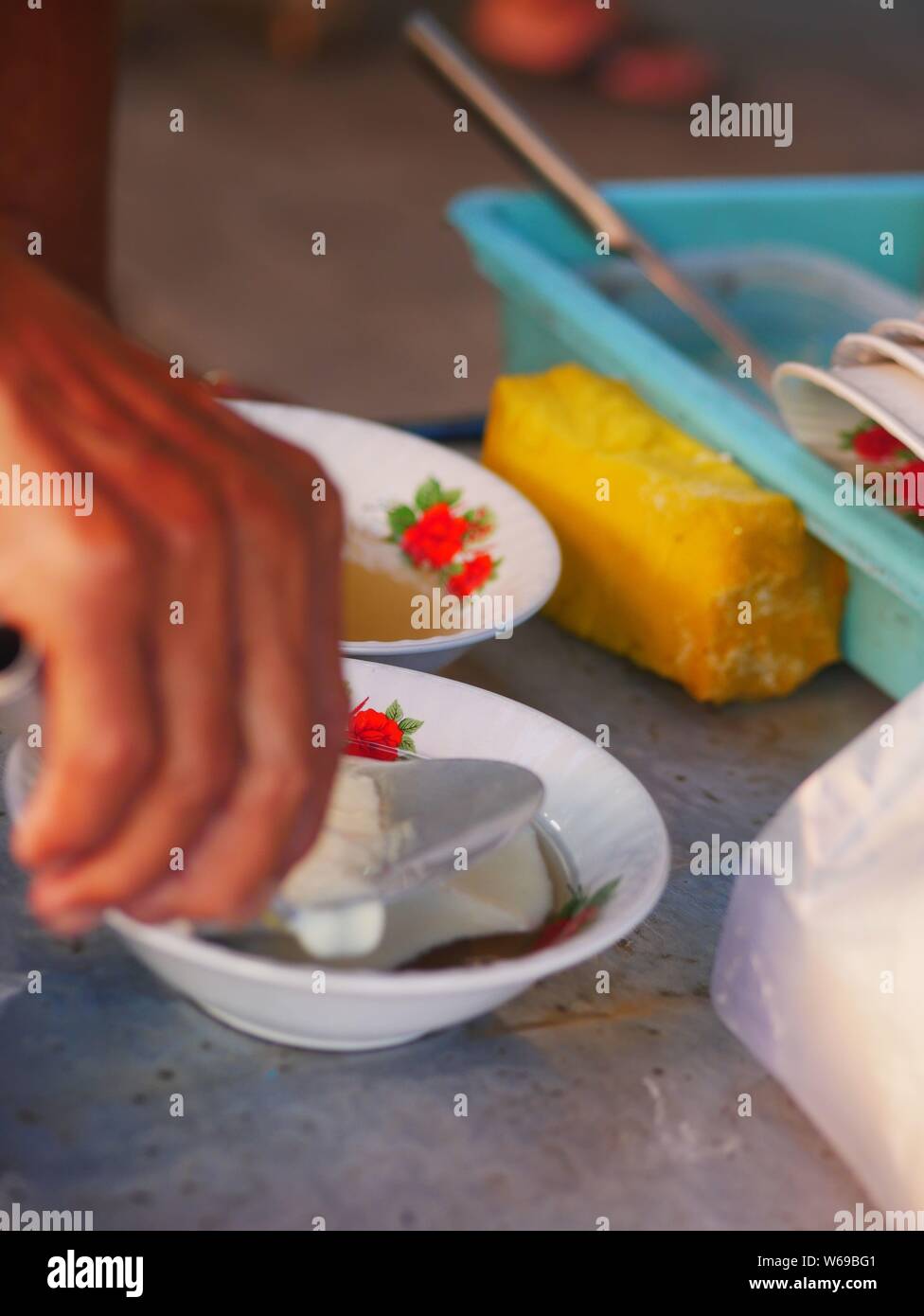 Verkäufer bereit tahok für Kunden. Tahok ist ein Pudding - wie Teller mit einem unverwechselbaren süßen Geschmack der javanischen Zucker. Stockfoto
