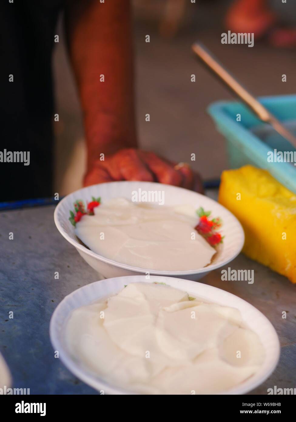 Verkäufer bereit tahok für Kunden. Tahok ist ein Pudding - wie Teller mit einem unverwechselbaren süßen Geschmack der javanischen Zucker. Stockfoto