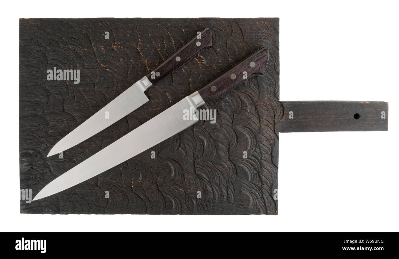 Kurze und lange Messer auf Holzbrett schossen von oben, isoliert auf weißem Stockfoto