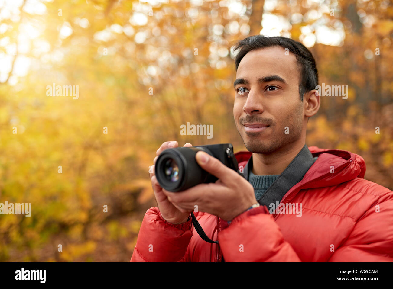 Attraktive inder Aufnehmen von Bildern mit einer spiegellosen Kamera durch den Wald im Herbst in Kanada Stockfoto