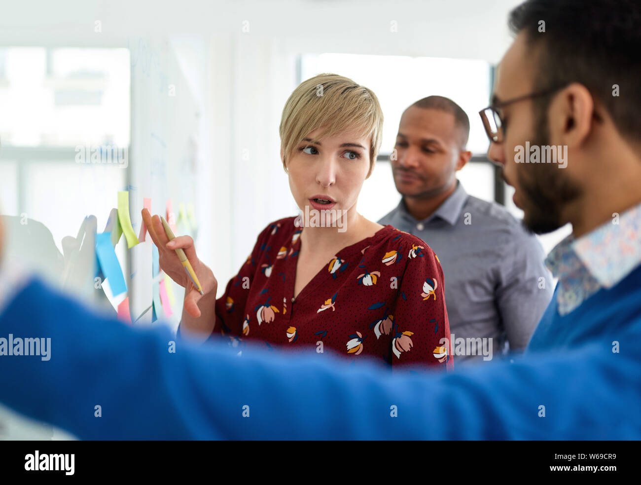 Porträt einer blonde kurze Haare Frau führt ein Team von Kreativen tausendjährigen Mitarbeiter in einem Anlauf Brainstorming Strategien Stockfoto