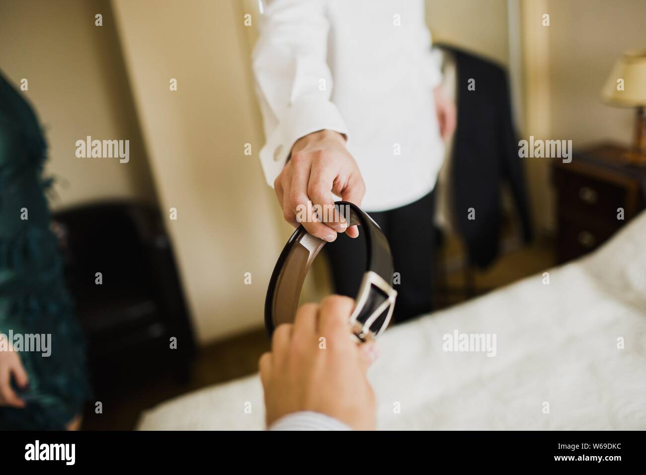 Ein Mann trägt seine Hochzeit Anzug, während jemand seinen Riemen mit der Hand geht. Stockfoto