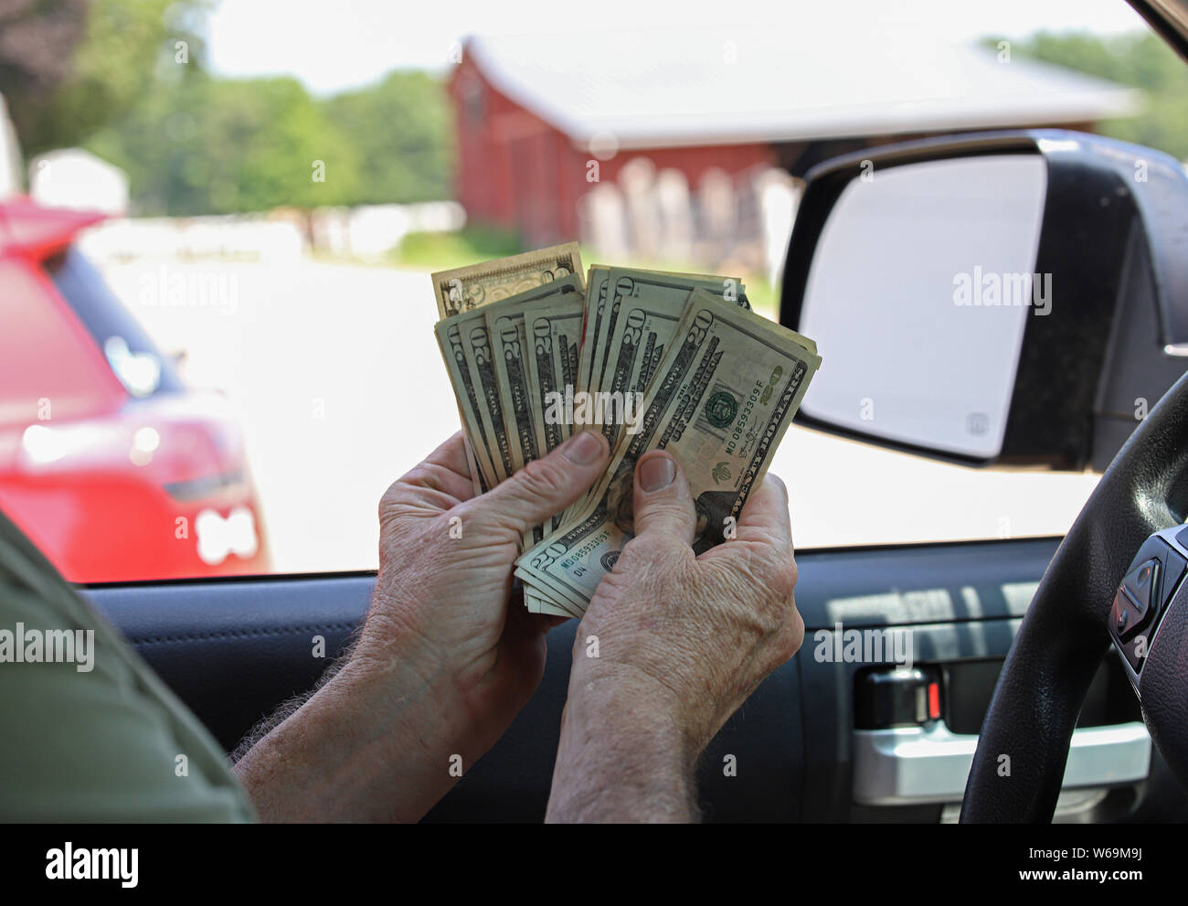 Geld zu gewinnen. Ein Mann mit Geld in seine Hände, blinkende Bargeld. Zahltag oder Arbeit Woche Geld und Währung. Stockfoto