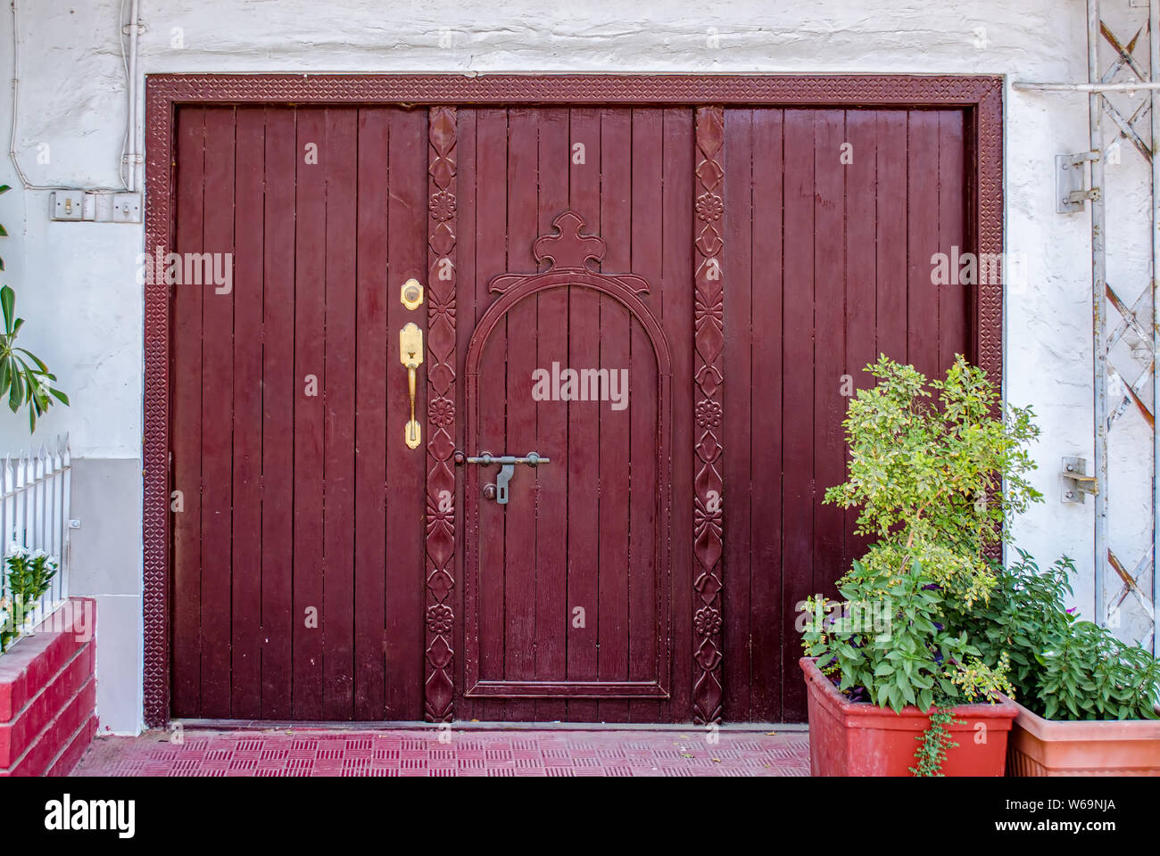 Alte, retro style maroon Heckklappe mit farblich passenden Holzrahmen mit komplizierten Kunst Handwerk. Von Muscat, Oman. Stockfoto