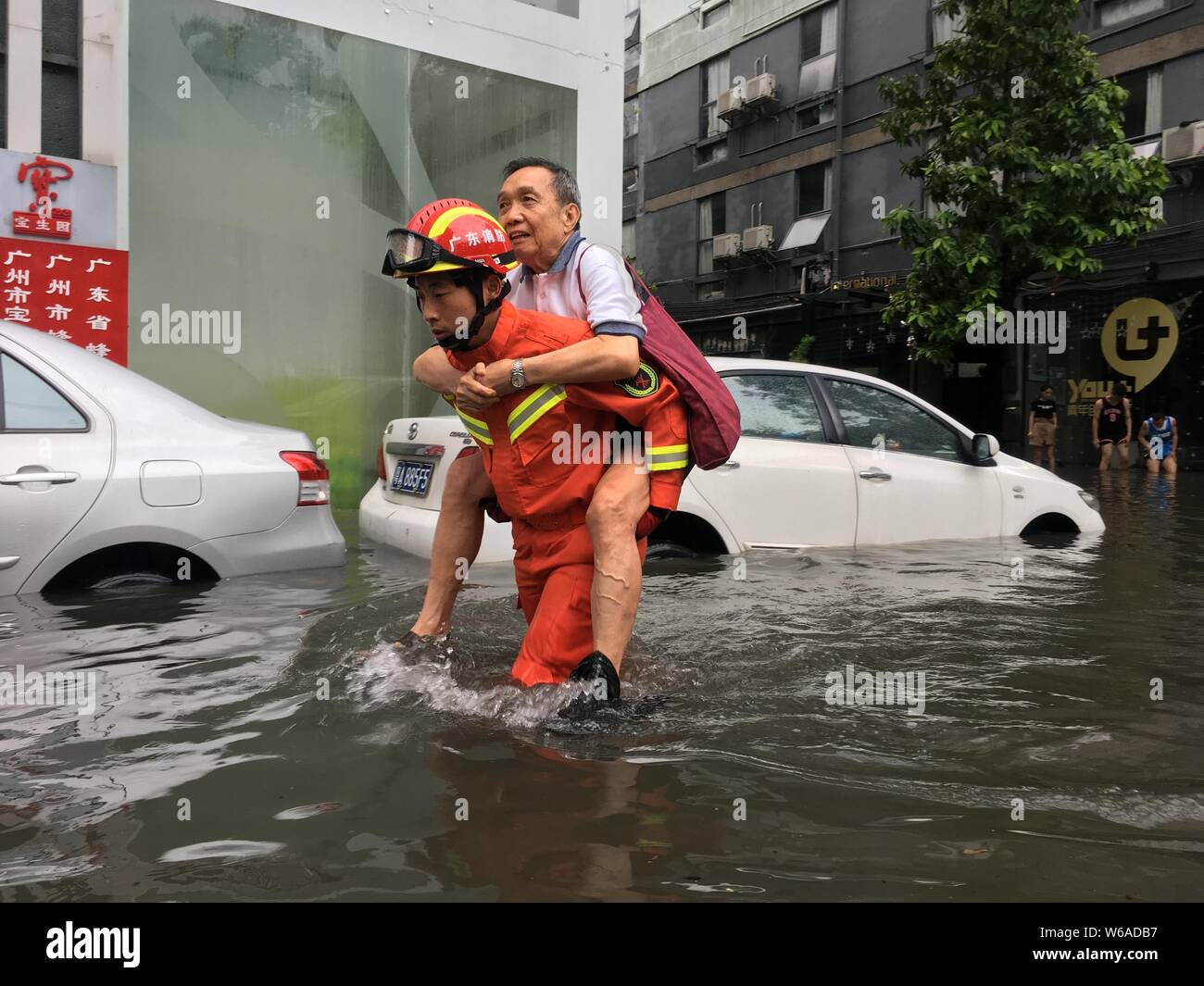 Eine chinesische Retter evakuiert Anwohner aus überschwemmten Gebieten verursacht durch einen schweren Regenguß und Typhoon Ewiniar in Guangzhou City, South China Guangd Stockfoto