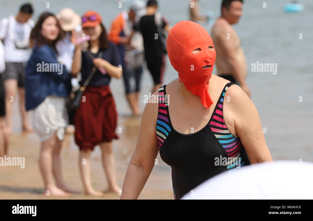 Eine Chinesische beachgoer trägt einen facekini wird dargestellt, an einem Beach Resort in Qingdao, Provinz Shandong, China, 20. Juni 2018. Stockfoto