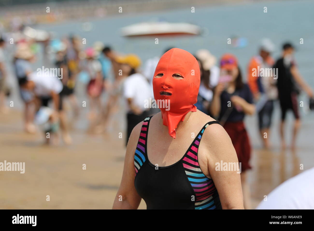 Eine Chinesische beachgoer trägt einen facekini wird dargestellt, an einem Beach Resort in Qingdao, Provinz Shandong, China, 20. Juni 2018. Stockfoto