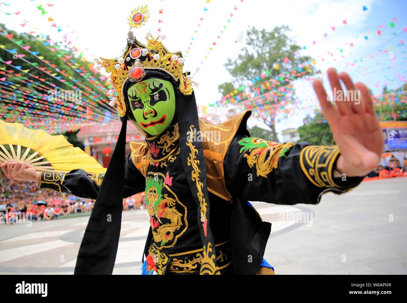Ein chinesischer Mann von Miao ethnische Gruppe in traditioneller Tracht führt schnelle Maske - Ändern der Sichuan Oper während der feuerwerkskörper Festival (Huapao Stockfoto