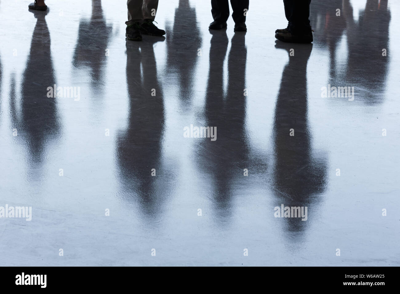 Schwarze Schatten einer Gruppe Menschen auf dem Boden. Stockfoto