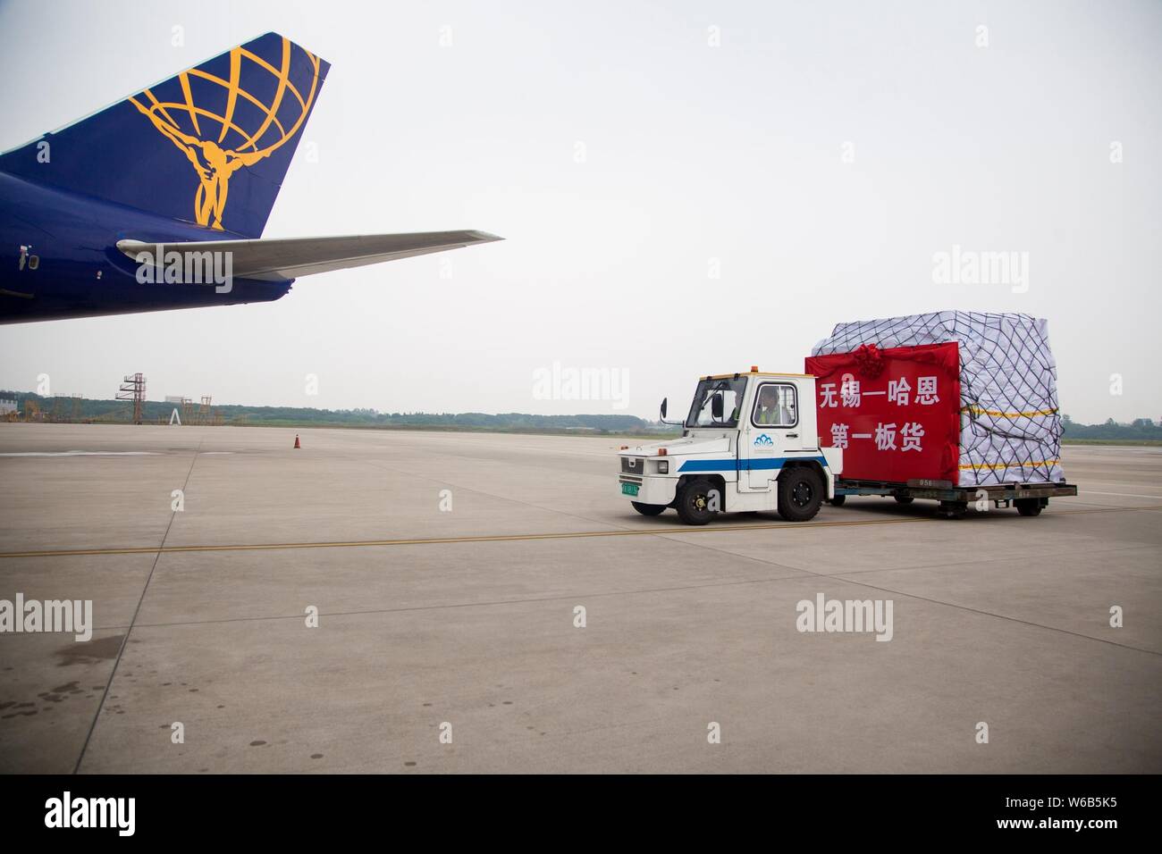 Chinesischen Boden Besatzungsmitglieder last Pakete auf eine Boeing 747-400 Frachter Düsenflugzeug von Atlas Air, bevor es Köpfe für Deutschlands Flughafen Frankfurt-Hahn ein Stockfoto