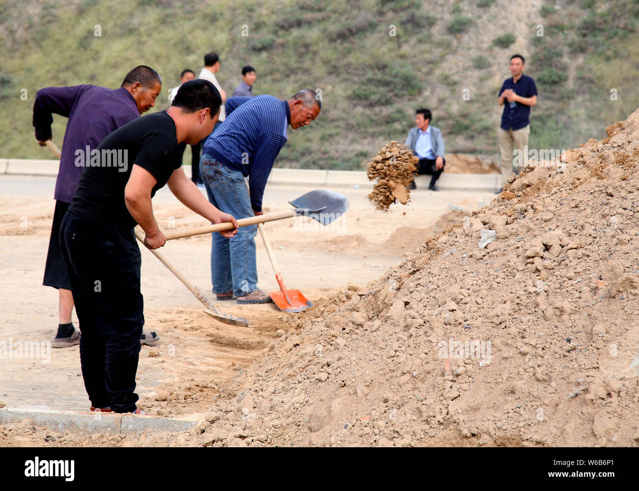 Chinesische Wanderarbeiter heben Sie den Graben in der Nähe der eisernen Kasten Häuser in der Mitte des National Highway 109 über unbezahlte Löhne für vier Jahre zu protestieren Stockfoto