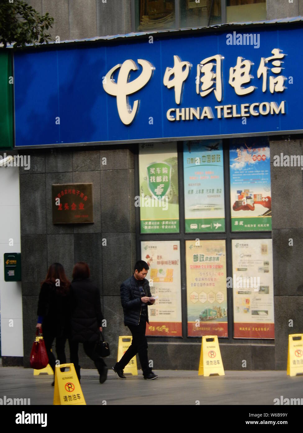 ---- Fußgänger vorbei an einem Zweig von China Telecom in Chongqing, China, 10. Januar 2018. Sat-Telefonnummern von China Telecom angeboten - Stockfoto