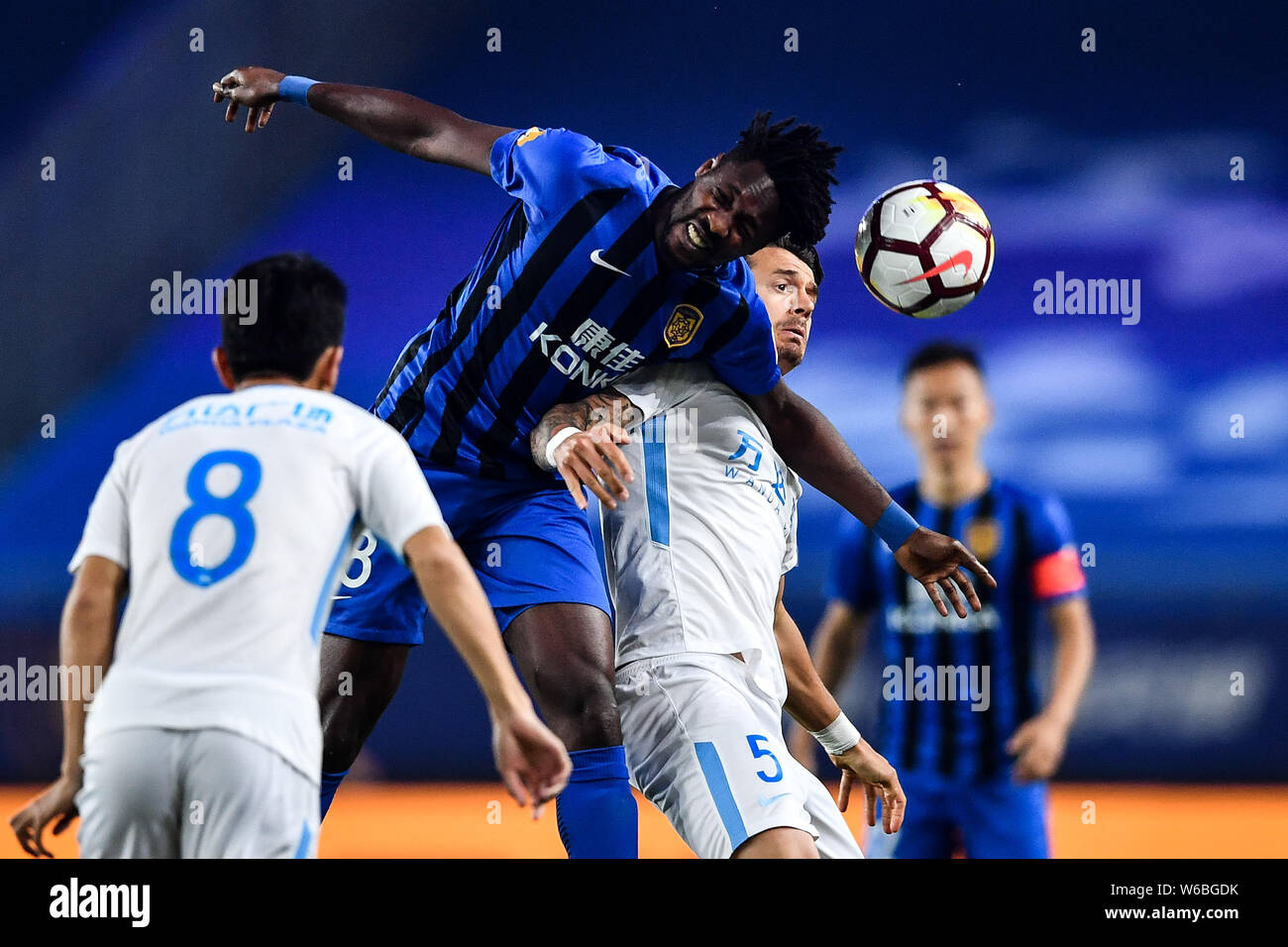 Ghanaischer Fußballspieler Richmond Boakye, top, der Jiangsu Suning Köpfe die Kugel ein Pass gegen Portugiesische Fußballspieler Jose Fonte von Dalian zu machen Stockfoto