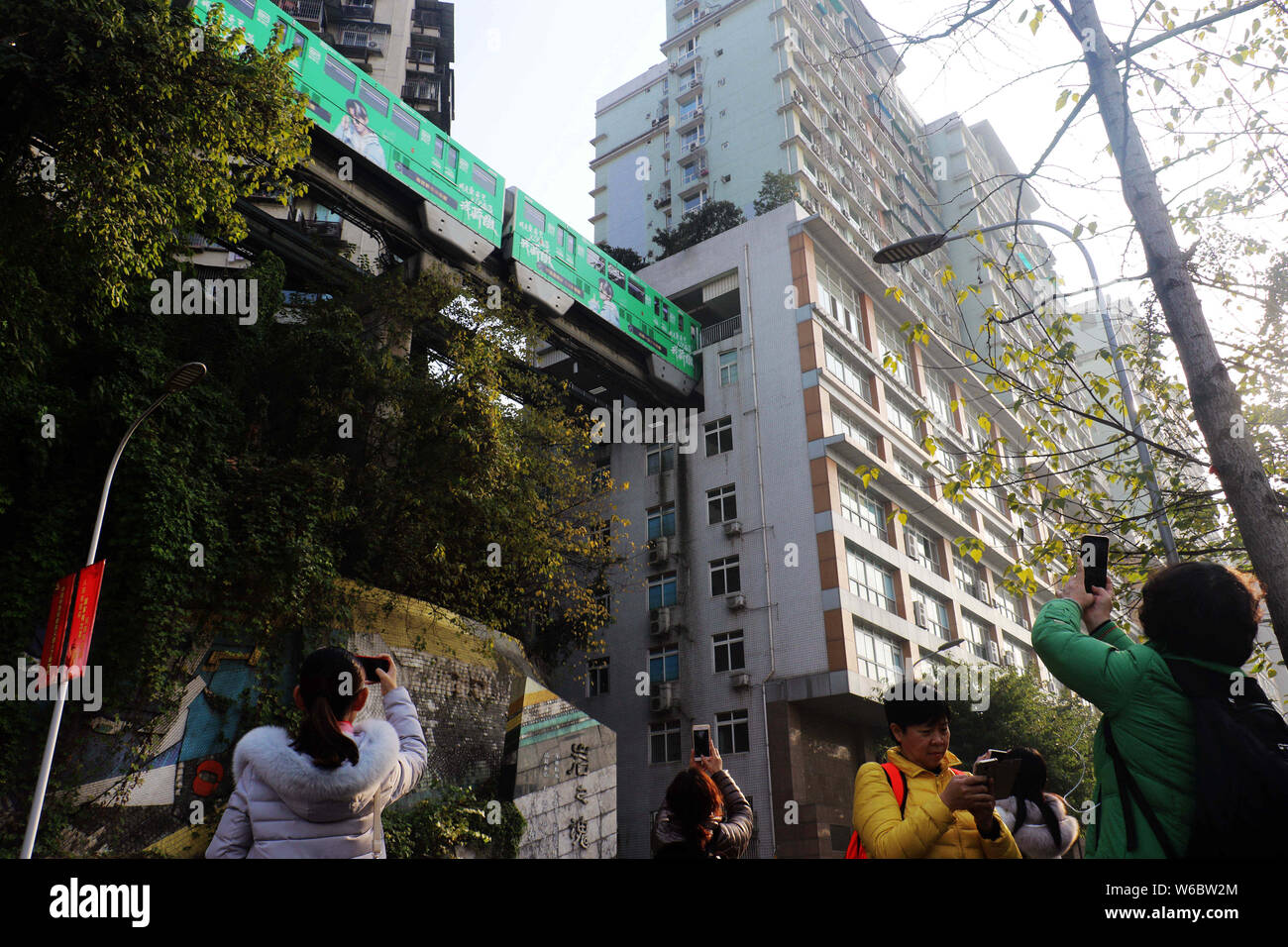 Die Nr. 2 der Stadtbahn Zug fährt durch ein Gebäude in Liziba Station, Chongqing Gemeinde. Chongqing, China's "Stadt der Berge', hat seine Licht Stockfoto