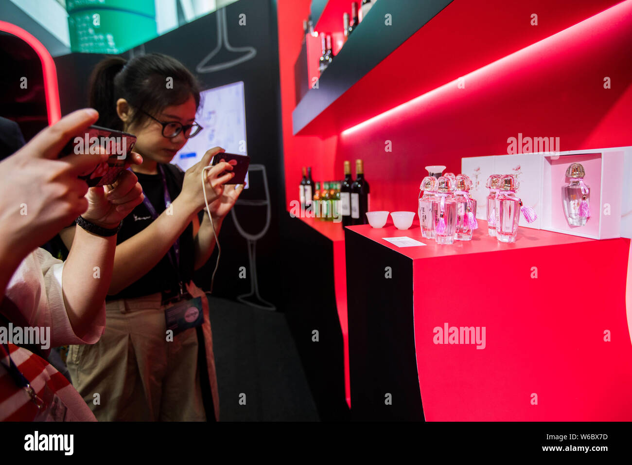 Ein Besucher nimmt Fotos von Flaschen mit Cocktail mit der Form der Chinesischen berühmte Marke Liushen Florida Wasser auf Darstellung während der Vinexpo Hong Kong Stockfoto