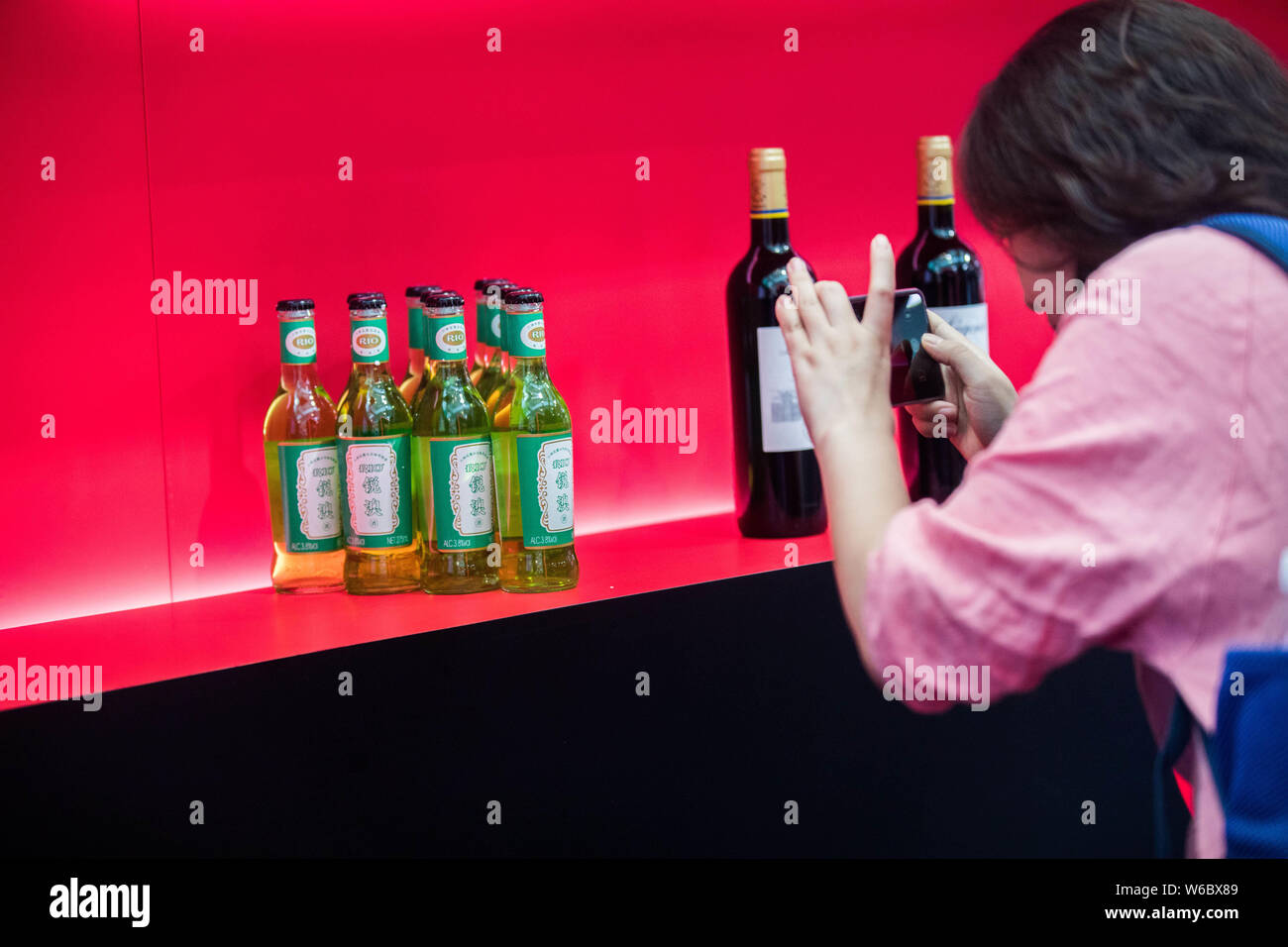 Ein Besucher nimmt Fotos von Flaschen mit Cocktail mit der Form der Chinesischen berühmte Marke Liushen Florida Wasser auf Darstellung während der Vinexpo Hong Kong Stockfoto
