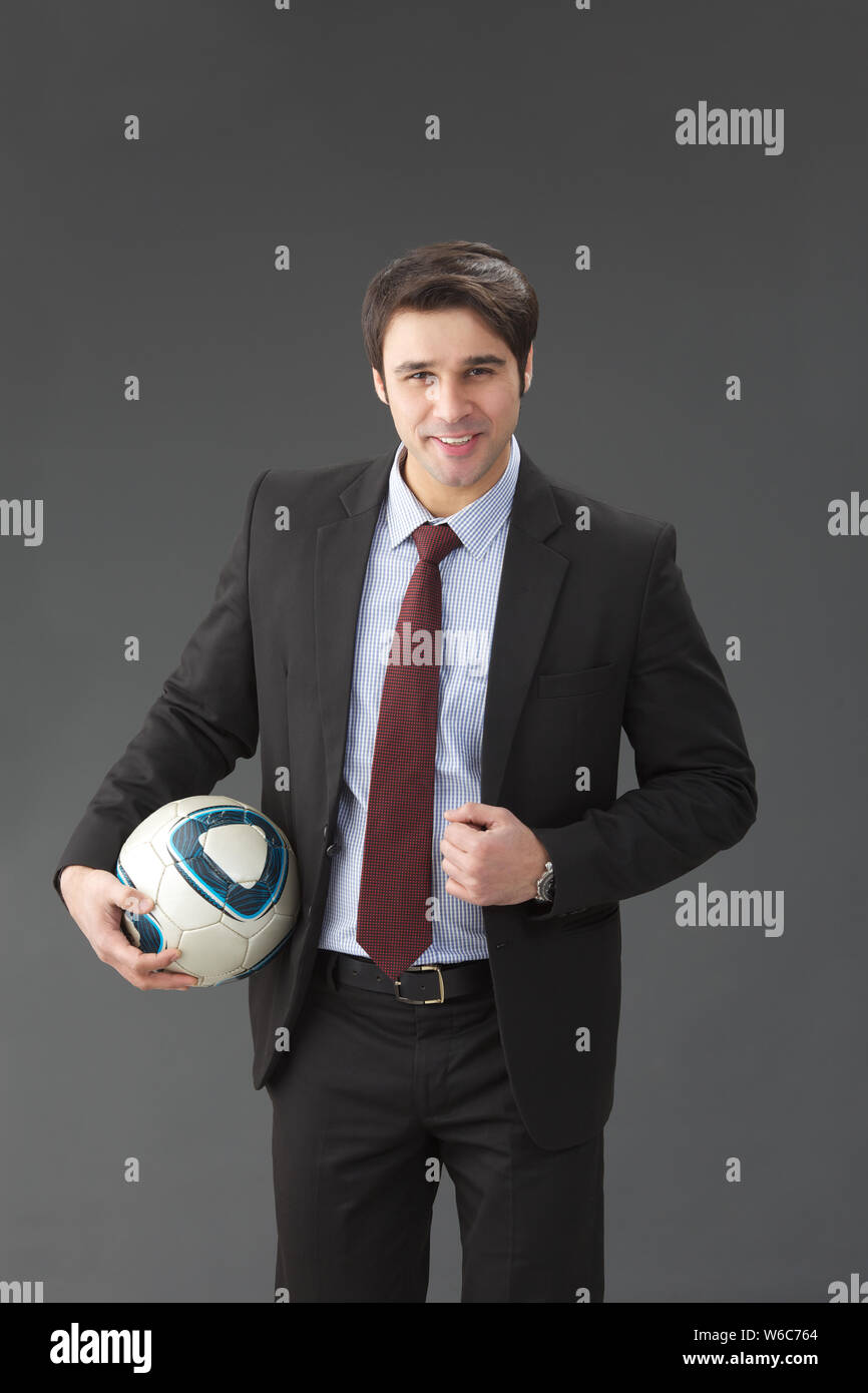 Geschäftsmann hält eine Fußball-Kugel-Lächeln Stockfoto